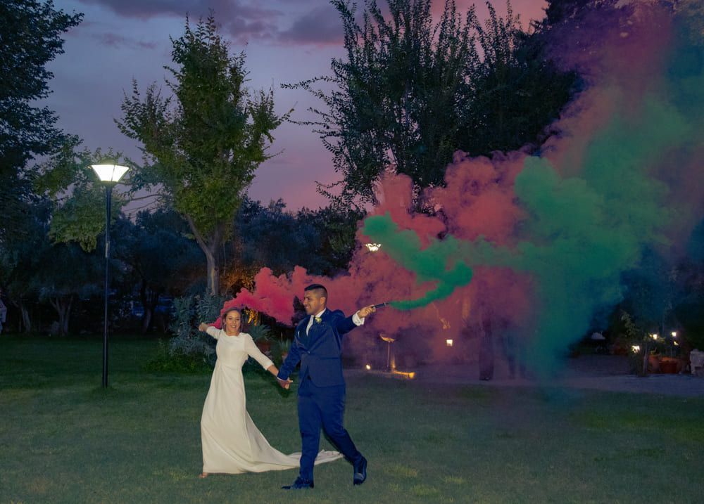 Novios bajo paseo de álamos con bengalas de noche en Finca Villa Mercedes